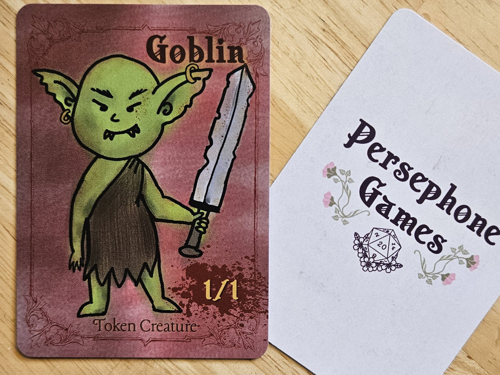 Illustrated goblin token card featuring a green goblin brandishing a worn sword
