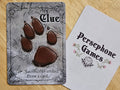 Illustrated clue token card featuring a red paw print on a stone textured background